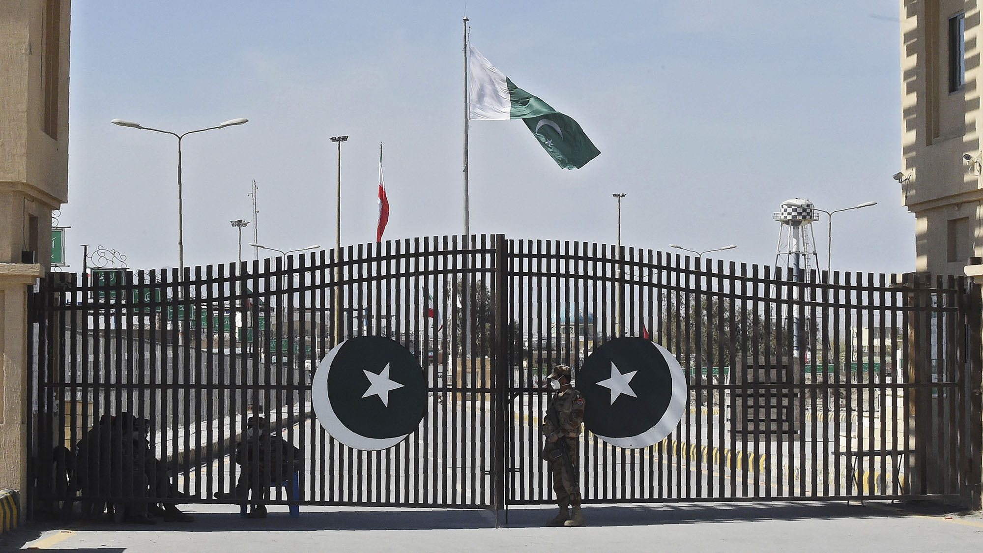 In this file photo, Pakistani soldiers wearing facemasks stand guard at the closed Pakistan-Iran border in Taftan on February 25, 2020 as fears over the spread of the COVID-19 coronavirus escalate following an outbreak in neighboring Iran. (AFP)