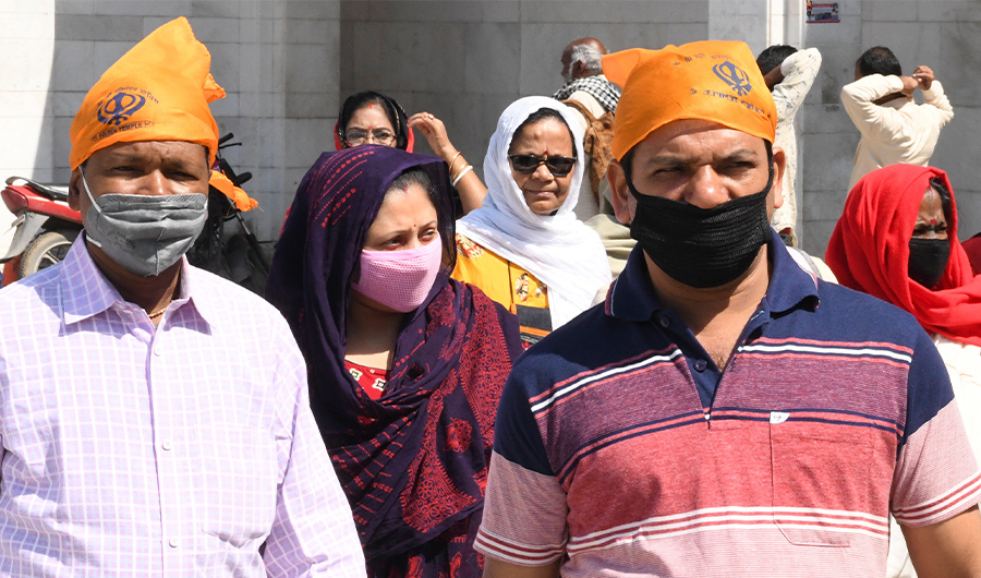 People wearing facemasks amid concerns over the spread of the COVID-19 novel coronavirus, walk through the heritage street in Amritsar on March 15, 2020. (AFP)