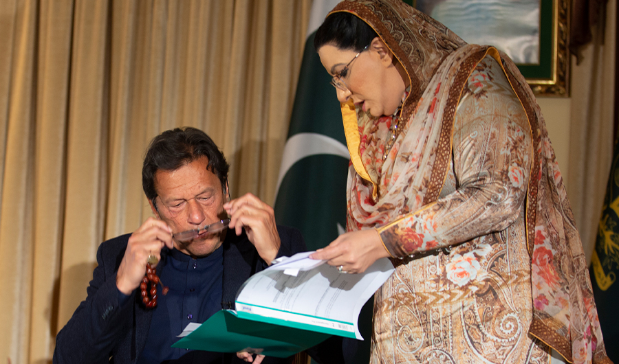 Pakistan government spokesperson Firdous Ashiq Awan consults with Pakistani Prime Minister Imran Khan in Islamabad, Pakistan, Monday, March 16, 2020. Khan said Monday he fears the new coronavirus will devastate developing nations' economies, and warned richer economies to prepare to write off the debts of the world's poorer countries. (AP)