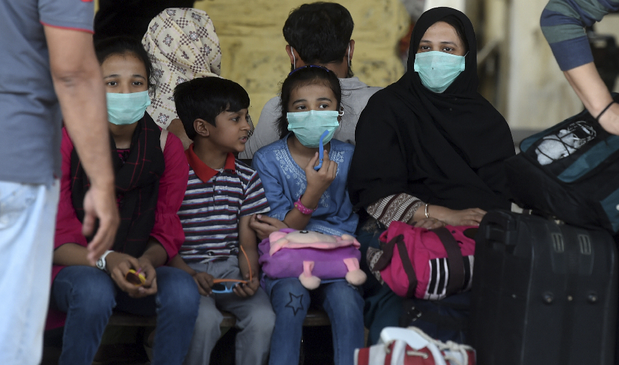 Passengers wearing facemasks amid concerns over the spread of the COVID-19 novel coronavirus, wait at Karachi Cantonment railway station in Karachi on March 16, 2020. (AFP)