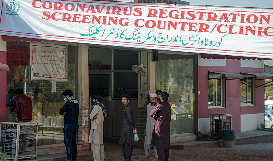 Residents wearing facemasks as a preventive measure against the COVID-19 coronavirus, wait for their turn at a coronavirus registration and screening counter at the Pakistan Institute of Medical Sciences Hospital in Islamabad on March 19, 2020. (AFP)