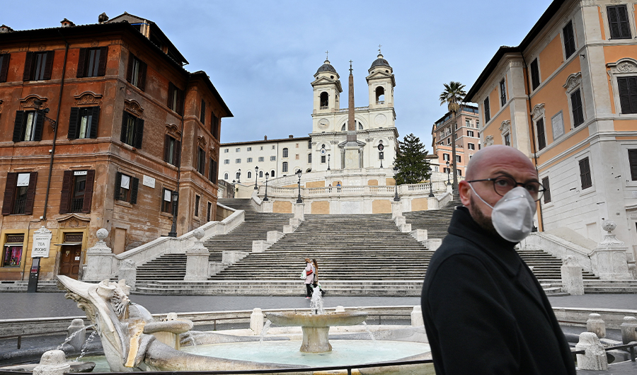 A man wearing a protection mask walks by the Spanish Steps at a deserted Piazza di Spagna in central Rome on March 12, 2020, as Italy shut all stores except for pharmacies and food shops in a desperate bid to halt the spread of a coronavirus. (AFP)