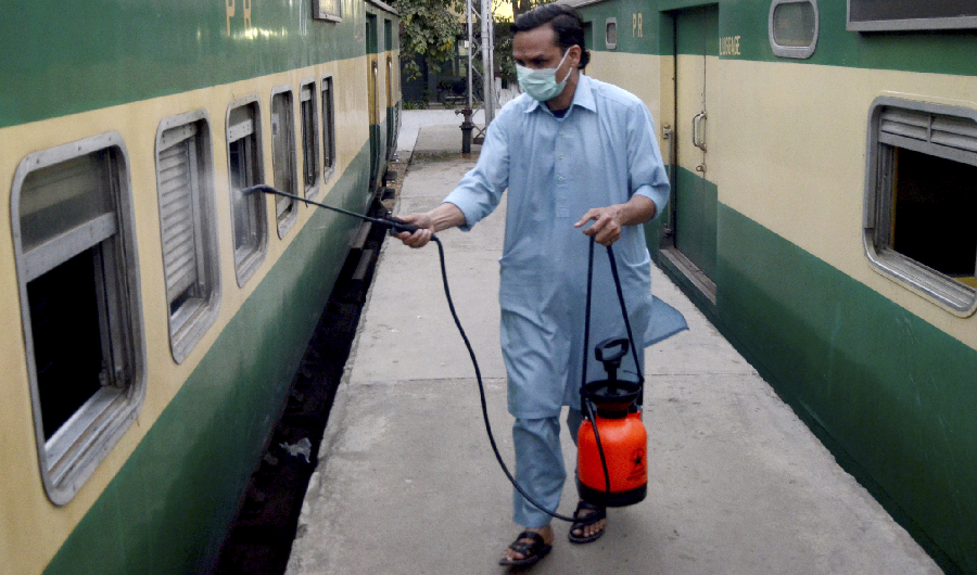 A worker disinfects a passenger train amid concerns over the spread of the COVID-19 novel coronavirus, at Karachi Cantonment railway station in Karachi on March 20, 2020. (AFP)