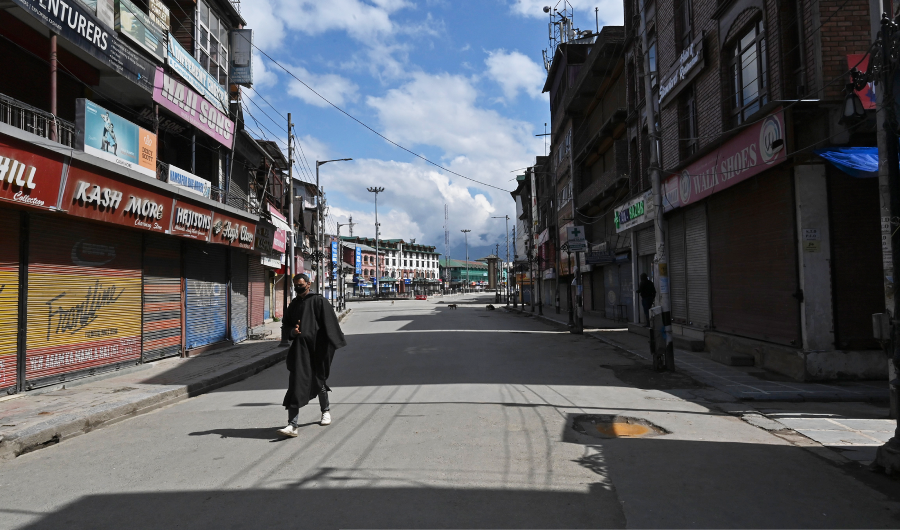 A man wearing a facemask walks along a deserted street during a government-imposed nationwide lockdown as a preventive measure against the COVID-19 coronavirus, in Srinagar on March 29, 2020. (AFP)