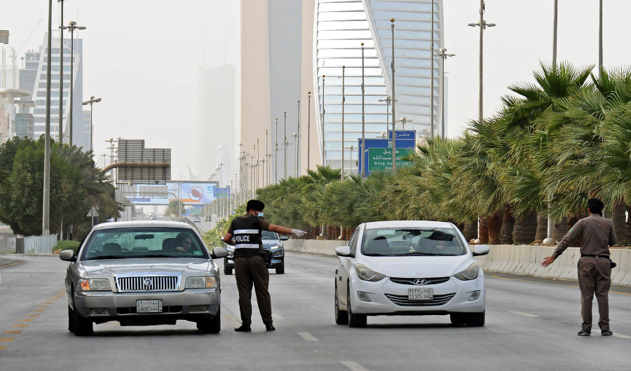 A picture taken on March 26, 2020, shows Saudi policemen manning a checkpoint on King Fahd road in the capital Riyadh, after the Kingdom began implementing an 11-hour nationwide curfew. (AFP)