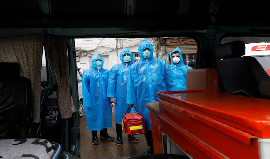 Volunteers of Edhi Foundation wear raincoats and boots as they pose during a drill on handling suspected carriers of the coronavirus disease (COVID-19) in Karachi on March 26, 2020. (REUTERS)