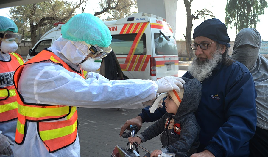 A Pakistani rescue personnel checks the body temperature of a boy during a drill exercise as a preventive measure for the spread of the of COVID-19 coronavirus, in Peshawar on March 1, 2020, as Pakistan has detected two new cases of the novel coronavirus. (AFP)