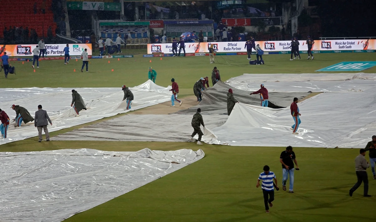 Ground staff at Gadaffi Stadium cover the wicket and the square just before heavy rain abandoned the Pakistan Super League match between title defender Quetta Gladiators and Multan Sultans in Lahore on March 11, 2020. (AP)