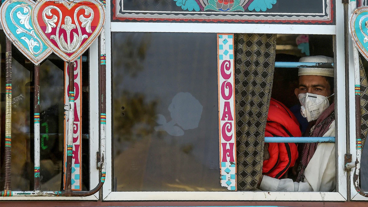 A passenger wearing a facemask as a prevention measure against the coronavirus sits in a bus in Karachi on March 11, 2020. (AFP)