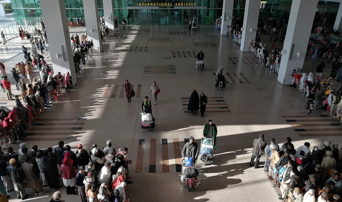 In this file photo, people gather to receive arriving passengers at the international arrival area of the Islamabad International Airport in Islamabad on Feb. 3, 2020. (AFP)