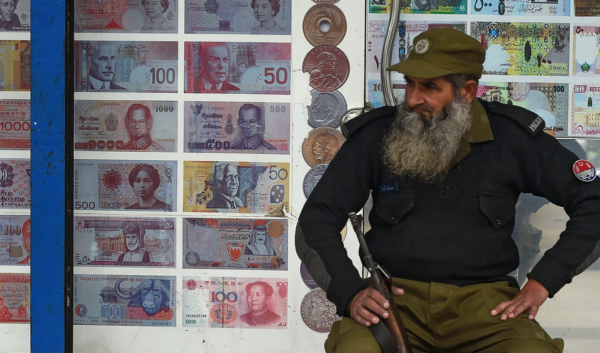 In this file photo, a Pakistani security guard sits outside the currency exchange shop in Lahore on Jan. 3, 2018. (AFP)