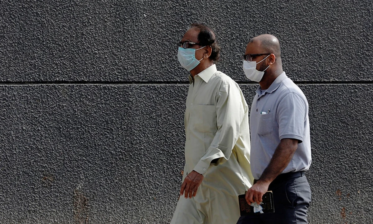 Men walk with face masks as a preventive measure, after Pakistan confirmed its first two cases of coronavirus, along a sidewalk in Karachi, Pakistan February 28, 2020. (REUTERS)