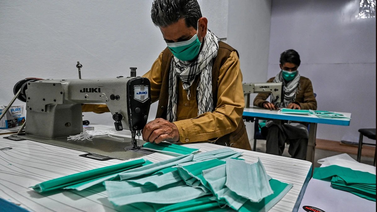 Workers make facemasks with sewing machines at a small factory during a government-imposed lockdown as a preventive measure against the COVID-19 coronavirus, in Rawalpindi on March 24, 2020. (AFP)