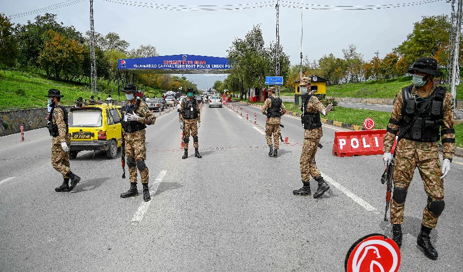 Security personnel wearing facemasks stand guard at a checkpoint at the city's entrance during lockdown as a preventive measure against the COVID-19 coronavirus in Islamabad on March 26, 2020. (AFP)