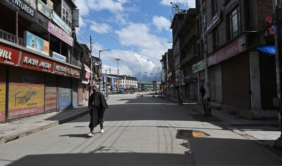 A man wearing a facemask walks along a deserted street during a government-imposed nationwide lockdown as a preventive measure against the COVID-19 coronavirus, in Srinagar on March 29, 2020. (AFP)