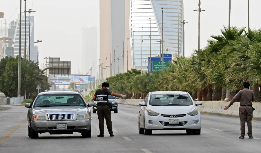 A picture taken on March 26, 2020, shows Saudi policemen manning a checkpoint on King Fahd road in the capital Riyadh, after the Kingdom began implementing an 11-hour nationwide curfew. (AFP)