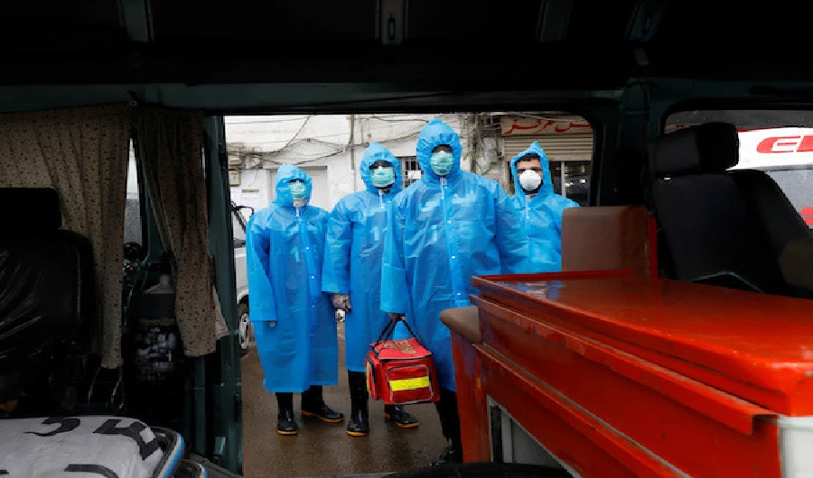 Volunteers of Edhi Foundation wear raincoats and boots as they pose during a drill on handling suspected carriers of the coronavirus disease (COVID-19) in Karachi on March 26, 2020. (REUTERS)