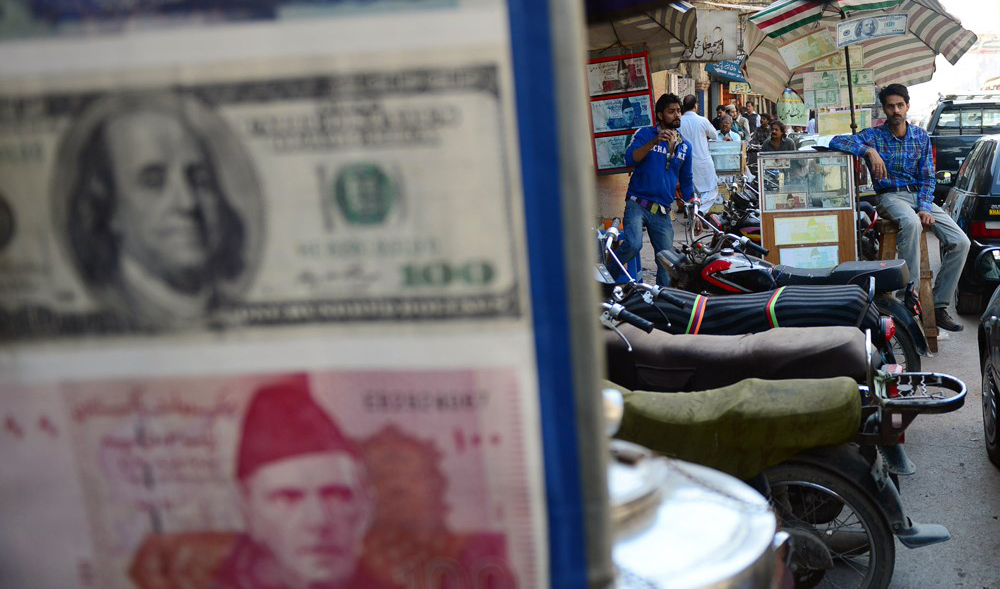 In this undated file photo, currency dealers wait for customers at a roadside money exchange stall in Karachi. (AFP)