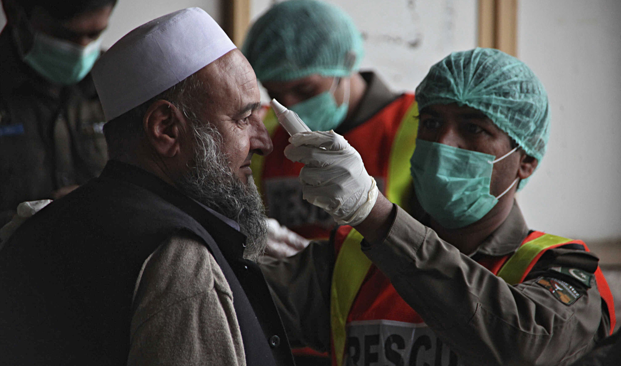 A health official of an emergency rescue service checks the body temperature of a government employee in Peshawar, Pakistan, March 12, 2020. A health official of an emergency rescue service checks the body temperature of a government employee in Peshawar, Pakistan, March 12, 2020. (AP)
