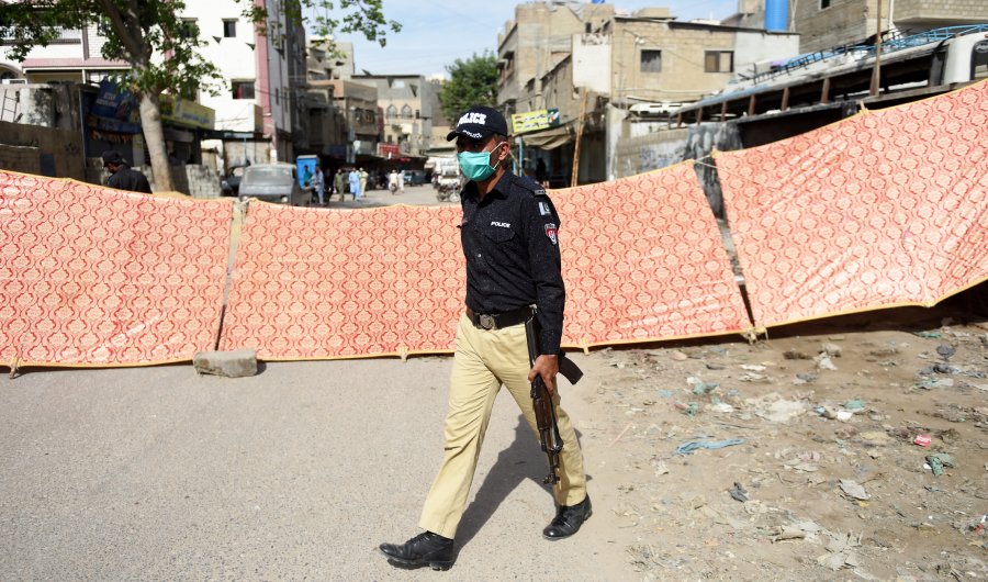 A policeman walks past a sealed area, after some people tested positive for coronavirus, during a government-imposed nationwide lockdown as a preventive measure against the COVID-19 coronavirus, in Karachi on April 14, 2020. (AFP)