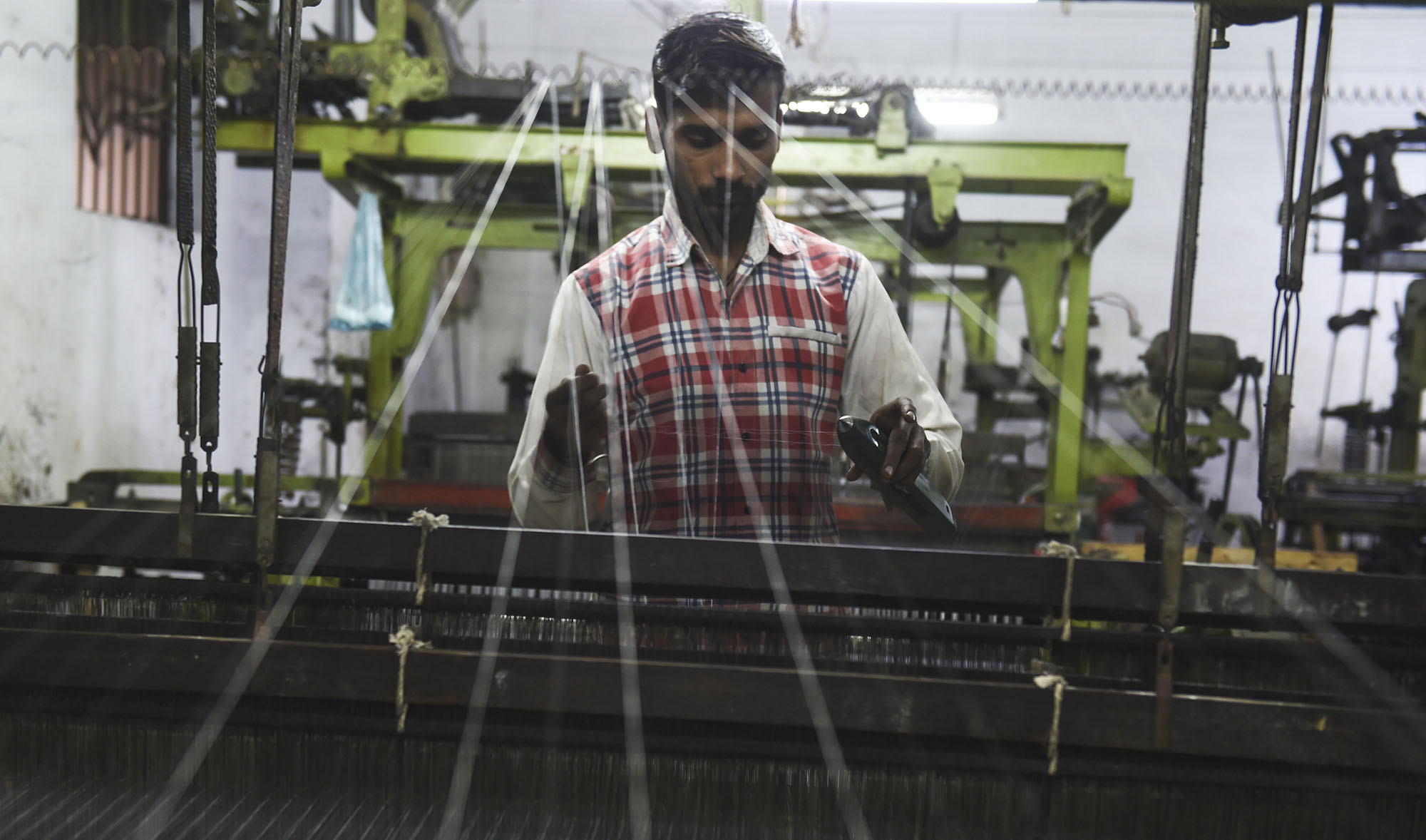 In this file photo, a laborer works on a loom at a factory in Pakistan's port city of Karachi on Jan. 17, 2020. (AFP)