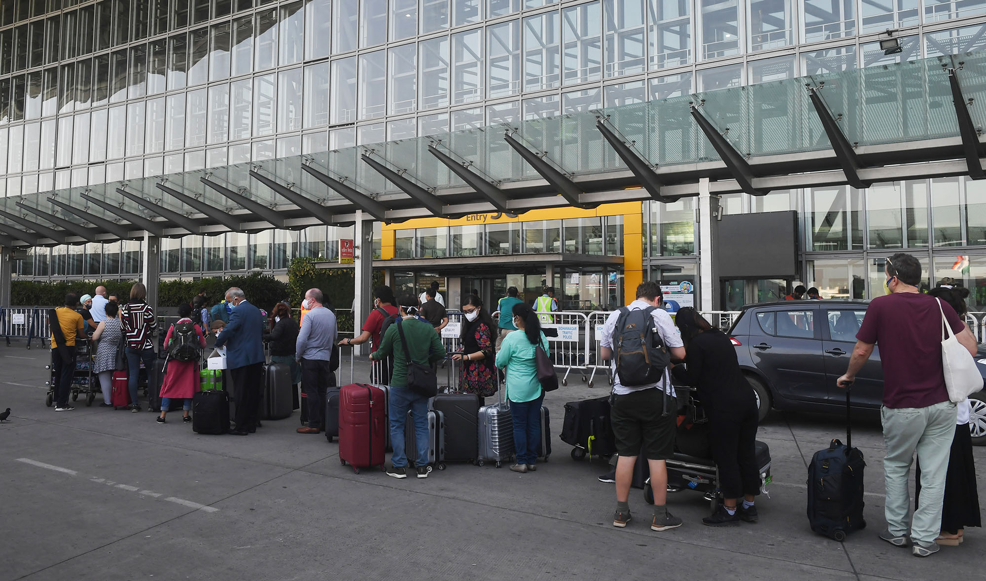 In this file photo, foreign nationals wearing facemasks line up outside the departure terminal of the Netaji Subhash Chandra Bose International Airport to board a special evacuation flight during a government-imposed nationwide lockdown as a preventive measure against the COVID-19 coronavirus, in Kolkata on March 31, 2020. (AFP)