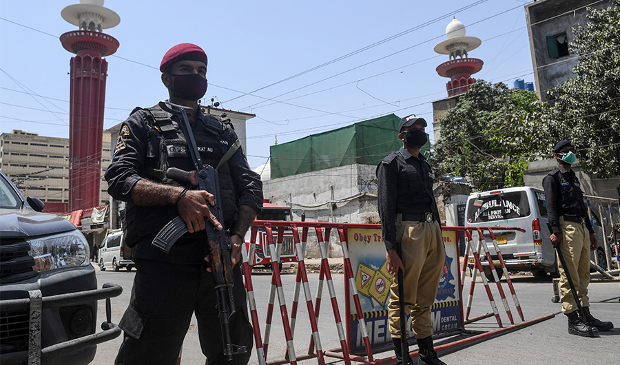 Policemen wearing facemasks stand guard outside a mosque during a government-imposed nationwide lockdown as a preventive measure against the COVID-19 coronavirus, in Karachi on March 27, 2020. (AFP)