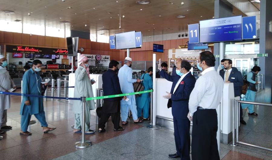Pakistani Umrah pilgrims arrive at the airport in Jeddah to board a special Saudi flight to Multan on April 18, 2020. Members of Pakistan's diplomatic mission in Saudi Arabia can also been seen in the picture. (Courtesy: Pakistan Consulate General in Jeddah)