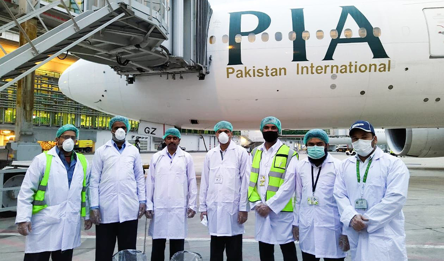 PIA staff wearing masks posing in front of a grounded PIA plane on Mar 21, 2020. (Courtesy: PIA twitter)