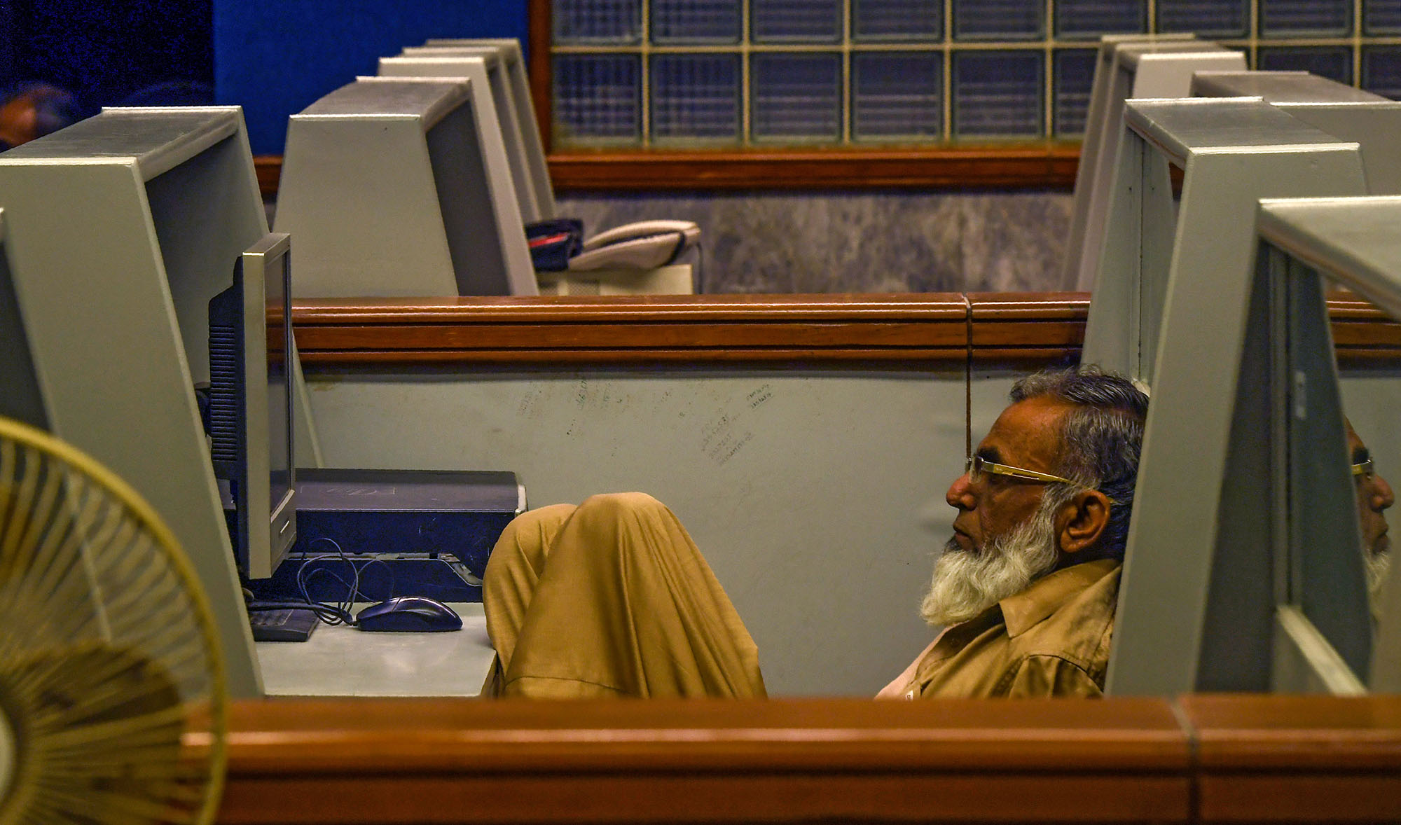 In this file photo, a stockbroker watches the latest share prices on a screen at an almost empty office of Pakistan Stock Exchange (PSX) during a government-imposed lockdown as a preventive measure against the COVID-19 coronavirus in Karachi on March 24, 2020. (AFP)