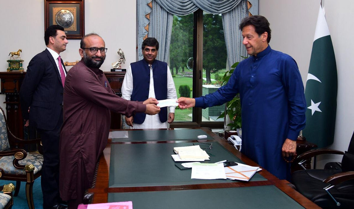 The photograph shows head of Edhi Foundation, Faisal Edhi, handing over a cheque of Rs10mln to Prime Minister Imran Khan in Islamabad on April 15, 2020. (Photo courtesy: PTI)