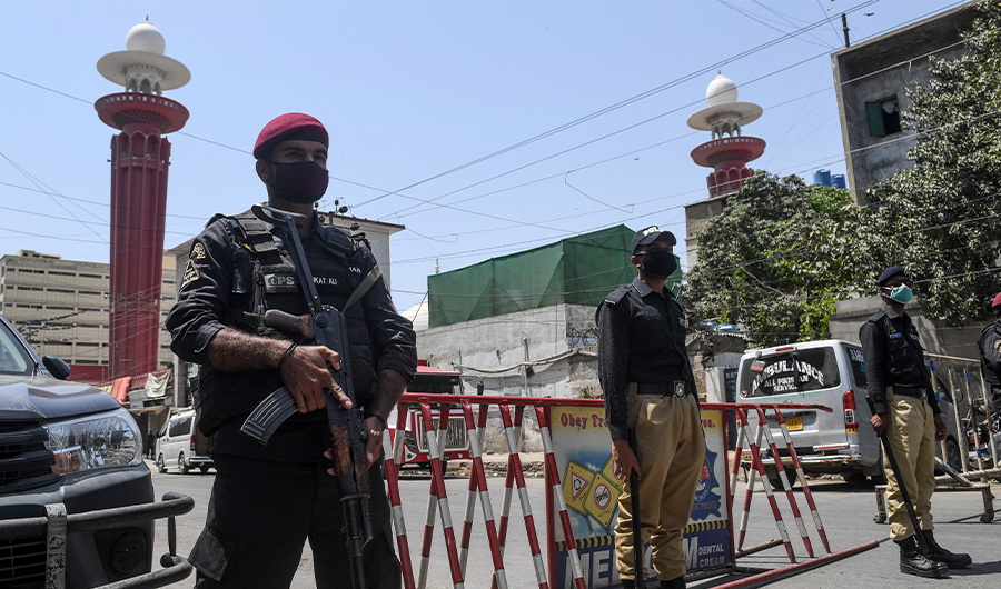 Security personnel wearing facemasks stand guard outside a closed mosque during a government-imposed nationwide lockdown as a preventive measure against the COVID-19 coronavirus, in Karachi on April 10, 2020. (AFP)