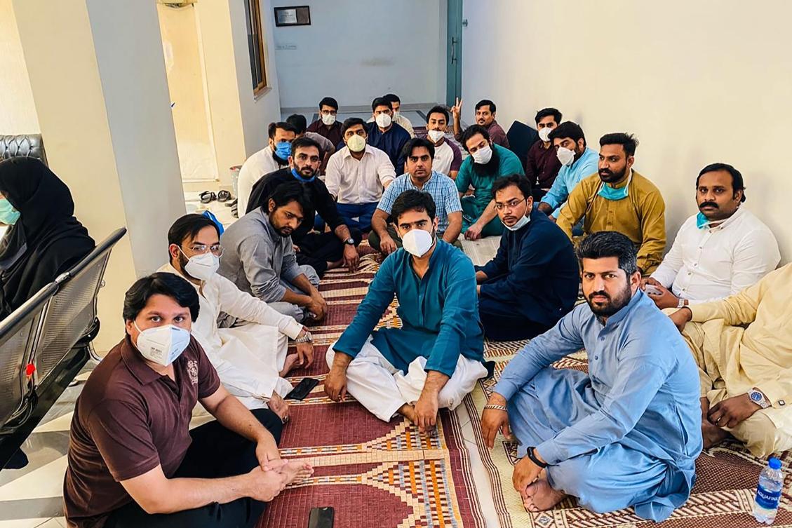 In this handout photograph released by the Young Doctors Association (YDA) Punjab and taken on April 24, 2020, doctors wearing facemasks sit in during a hunger strike protest at the Punjab Health Secretary in Lahore. (AFP/Young Doctors Association (YDA) Punjab)