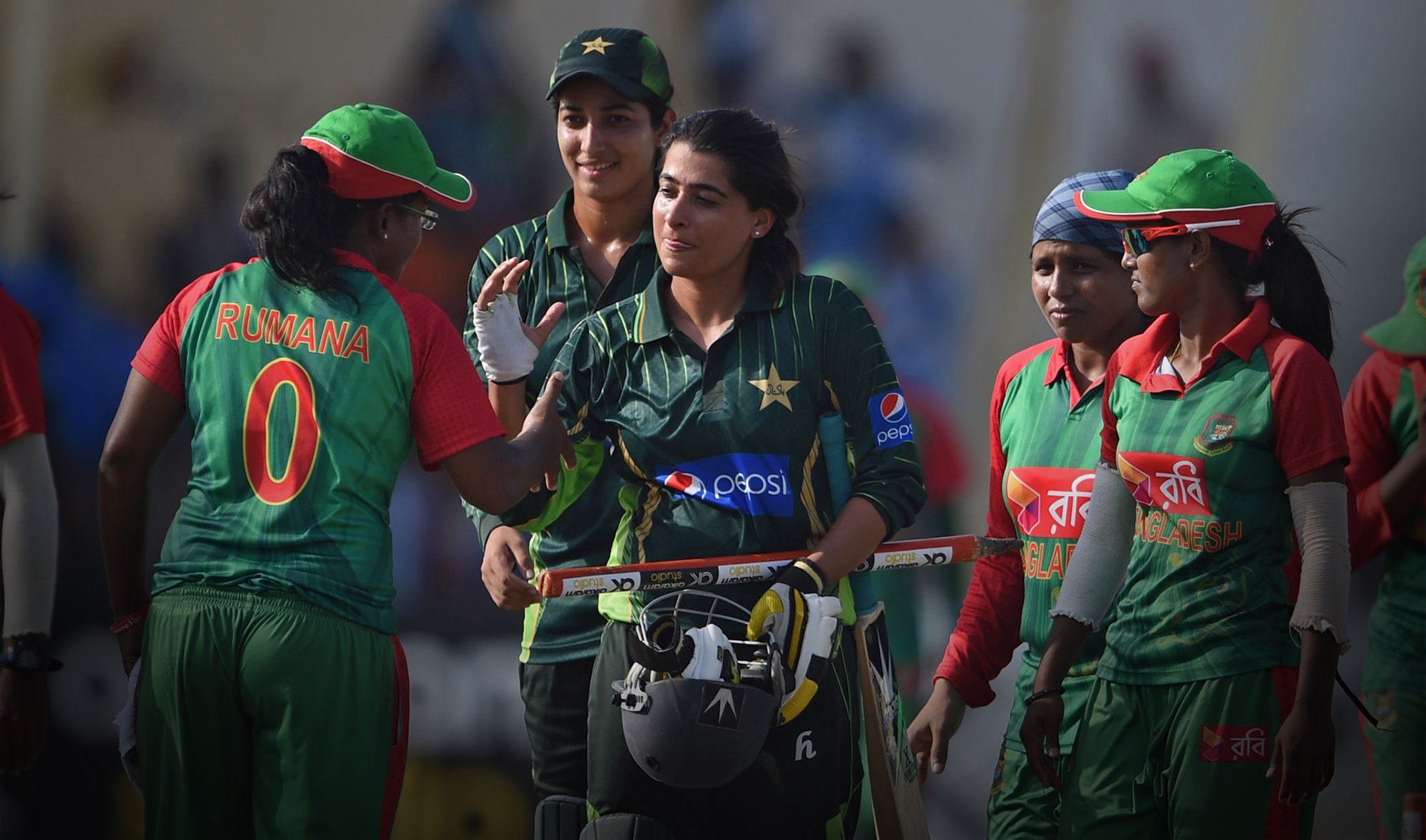 In this file photo, former Pakistani women's cricket team captain Sana Mir, center, shakes hands with a Bangladeshi player after winning the ODI series at the Southend Club in Karachi on Oct. 6, 2015. (AFP)