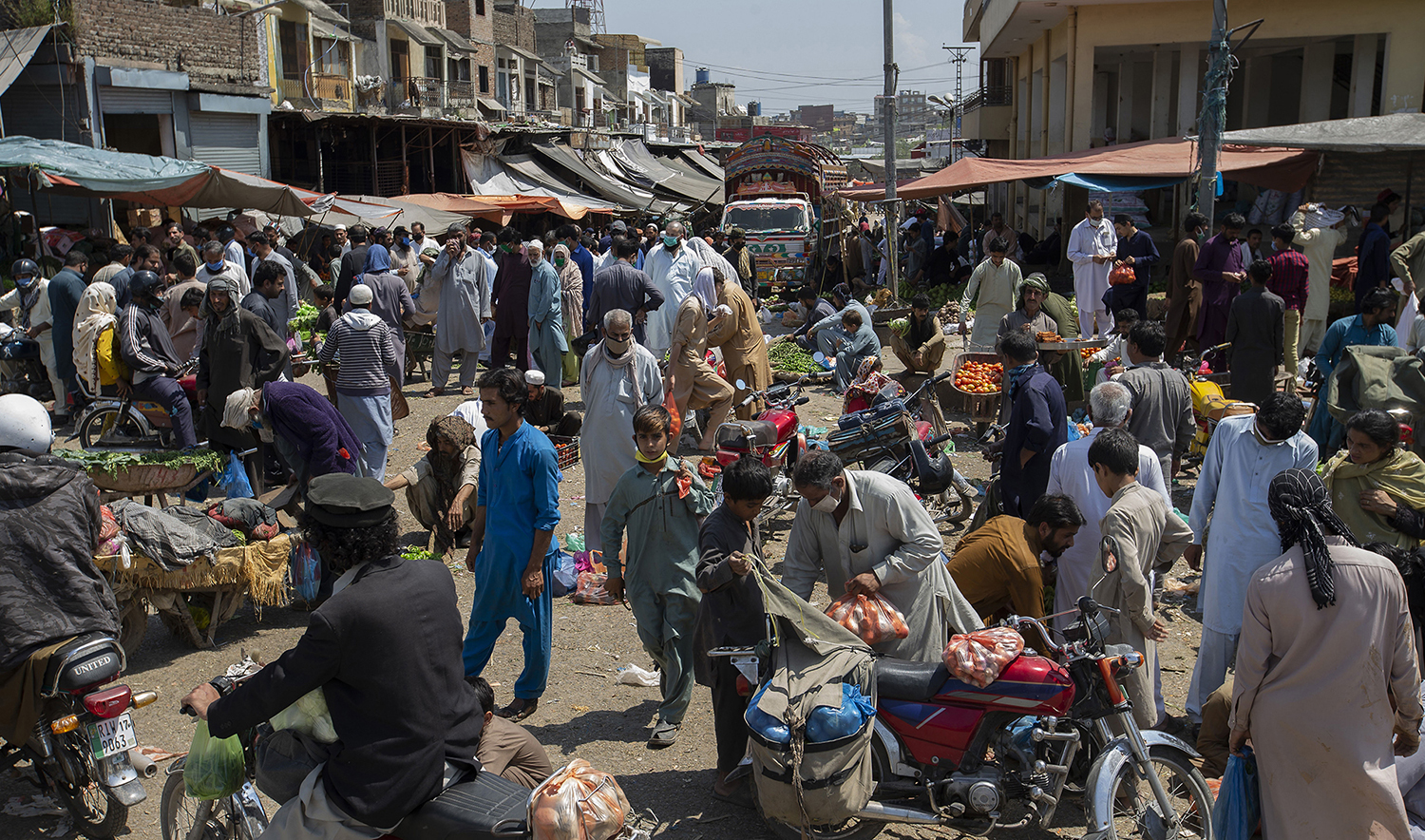 Consumers shopping for the upcoming Muslim fasting month of Ramadan ignore social distancing, during a lockdown to contain the spread of coronavirus, at a fruit and vegetable market in Islamabad, Pakistan, Tuesday, April 21, 2020. (AP)