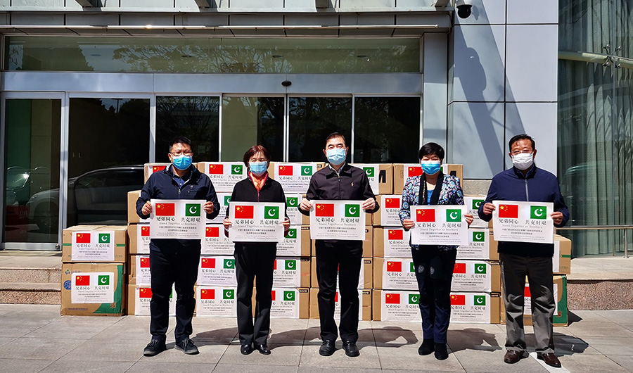 In this photo, Chinese officials pose in front of medical supplies being sent to Pakistan from China on April 24, 2020. (Courtesy: Chinese Embassy Pakistan)