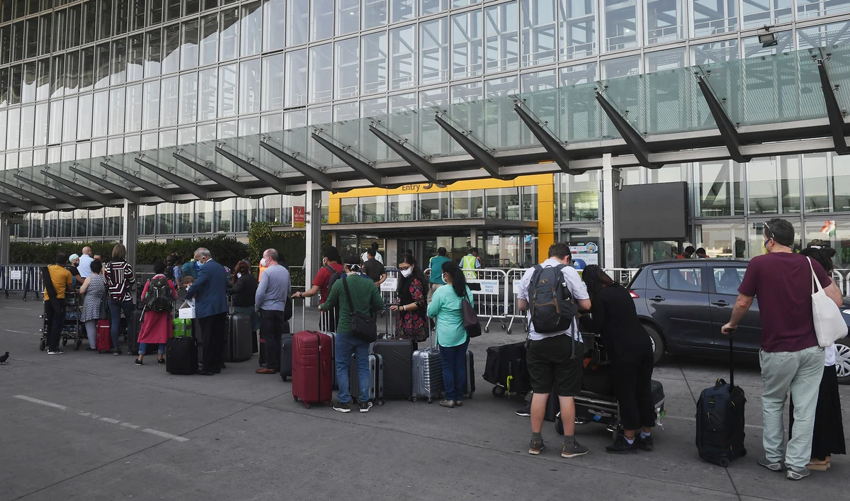 In this file photo, foreign nationals wearing facemasks line up outside the departure terminal of the Netaji Subhash Chandra Bose International Airport to board a special evacuation flight during a government-imposed nationwide lockdown as a preventive measure against the COVID-19 coronavirus, in Kolkata on March 31, 2020. (AFP)
