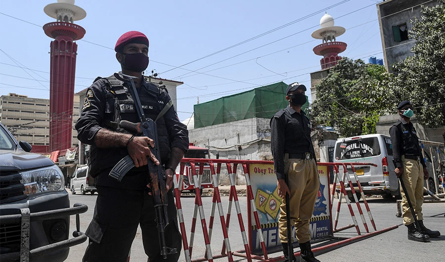 Policemen wearing facemasks stand guard outside a mosque during a government-imposed nationwide lockdown as a preventive measure against the COVID-19 coronavirus, in Karachi on March 27, 2020. (AFP)