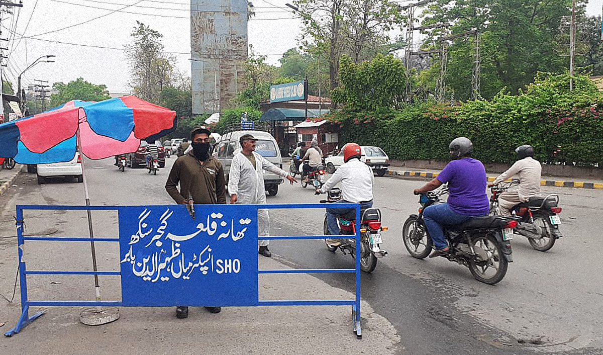 Police officers donning Personal Protective Equipment (PPE) perform their duties at a checkpoint in Lahore on May 2, 2020. (AN photo by Shafiq Malik)