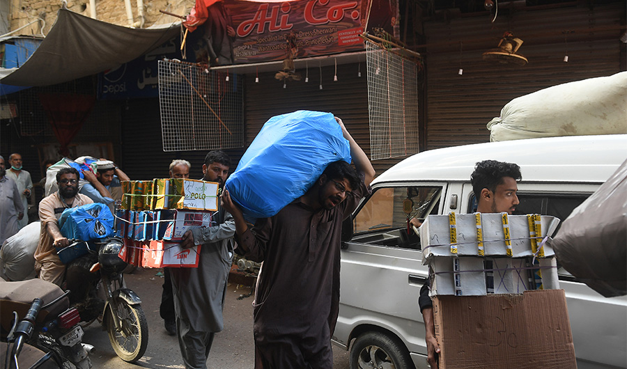 Shopkeepers move their products from a closed market after receiving permission form the local government for online sales during a government-imposed nationwide lockdown as a preventive measure against the COVID-19 coronavirus, in Karachi on April 28, 2020. (AFP)