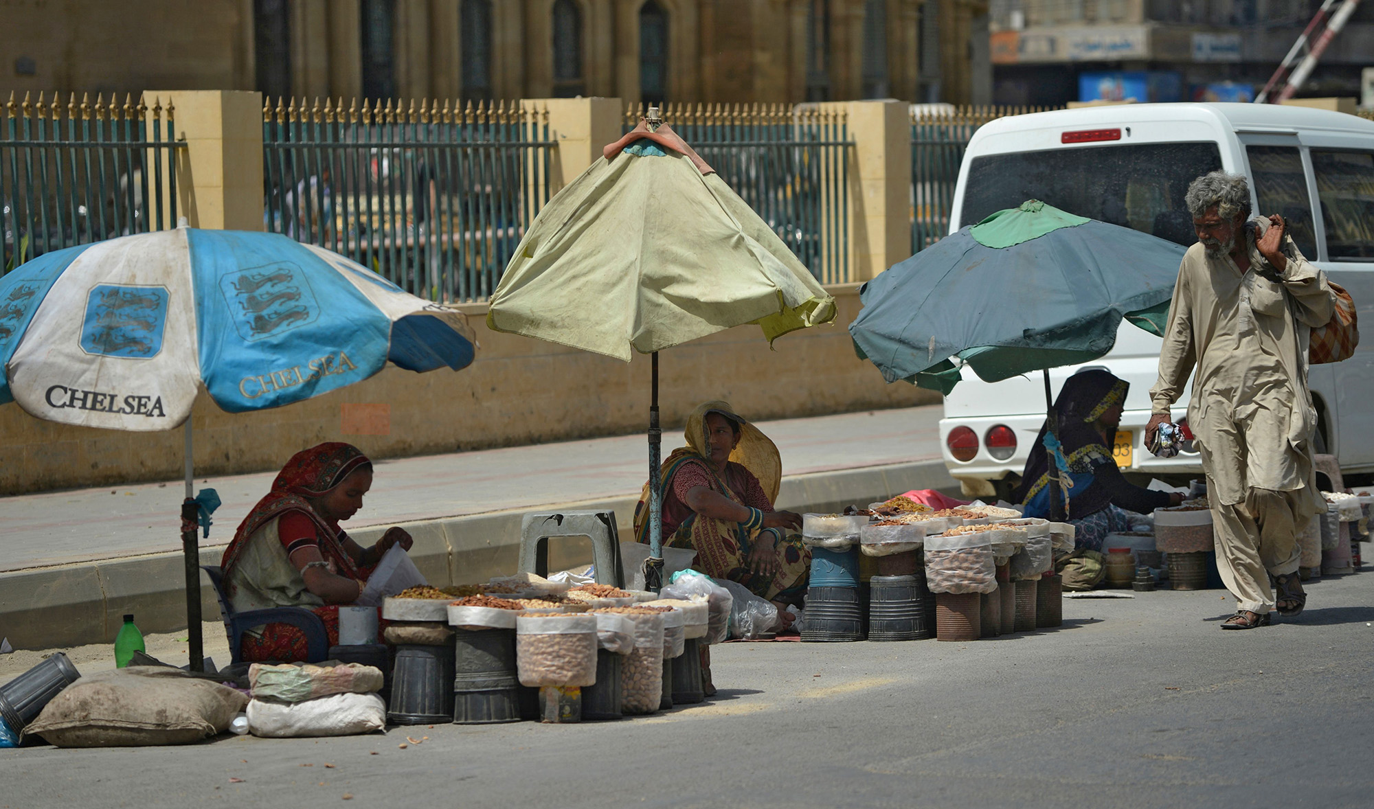Women vendors wait for customers alongside a street during a government-imposed nationwide lockdown as a preventive measure against the COVID-19 coronavirus in Karachi on May 4, 2020. (AFP)