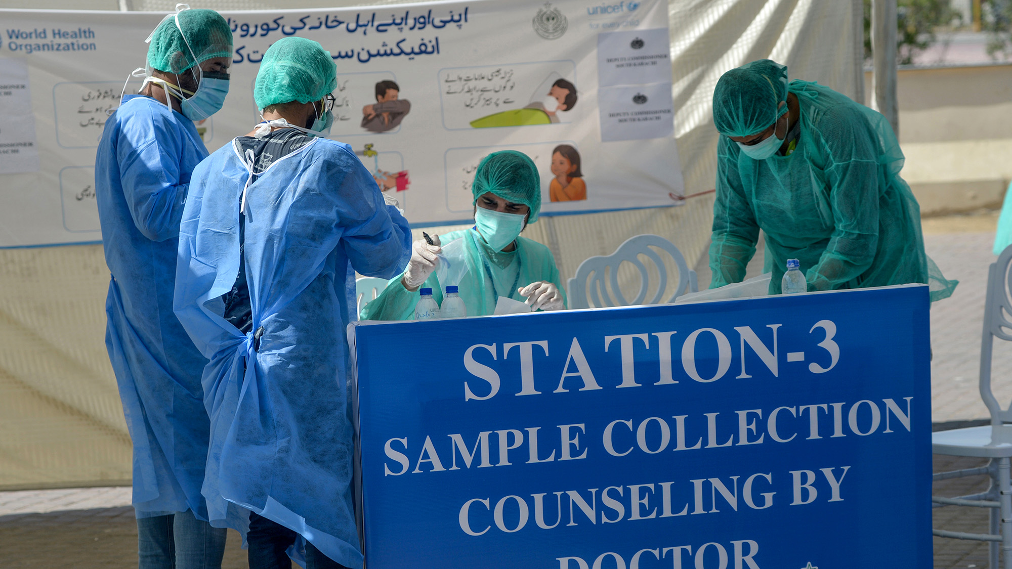 In this file photo, medical staff members wearing protective gear work on a desk at a drive-through screening and testing facility point during a government-imposed nationwide lockdown as a preventive measure against the COVID-19 coronavirus in Karachi on April 4, 2020. (AFP)
