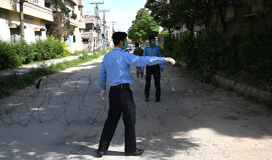 Policemen wearing facemasks seal off a street of a residential area with barbed wire after some people tested positive for coronavirus during a government-imposed nationwide lockdown as a preventive measure against the COVID-19 coronavirus, in Islamabad on April 30, 2020. (AFP)