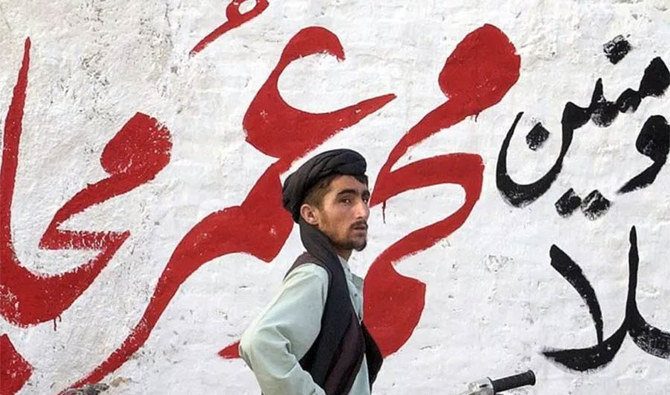 A pro-Taliban supporter standing in front of a graffiti reading "Ameer-ul-Momneen Mullah Muhammad Omar Mujahid Zindabad (long live holy fighter)" in Killi Nalai, a village near the Pakistan-Afghanistan border on June 01, 2007 ( AFP/file photo)
