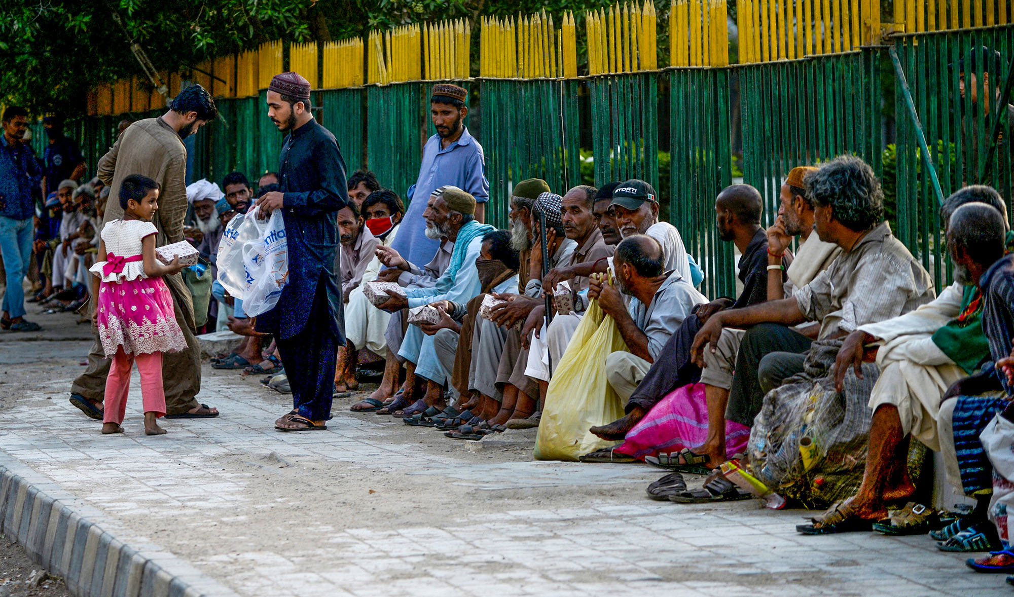 In this file photo, men distribute food to people during a government-imposed anti-coronavirus lockdown in Karachi on May 2, 2020. (AFP)
