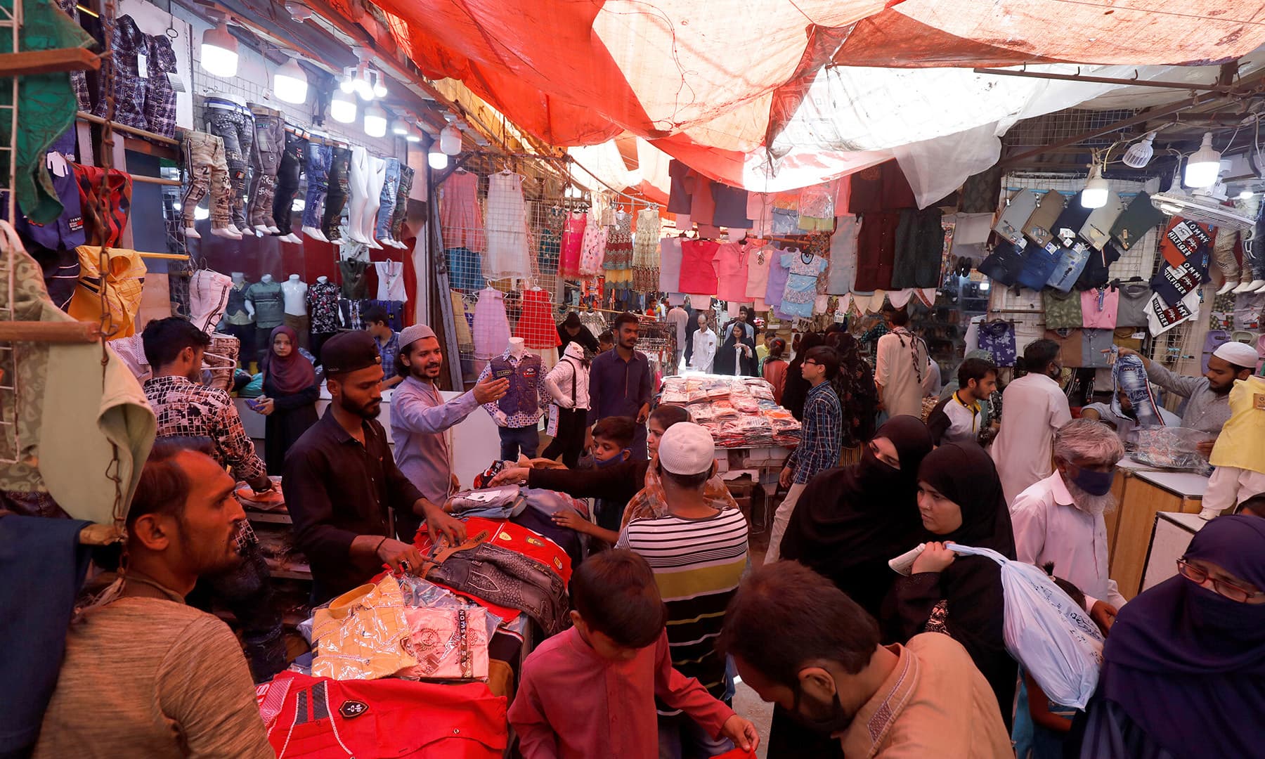 People shop from stalls in a market, after Pakistan started easing the lockdown as the coronavirus disease (COVID-19) continues, in Karachi, Pakistan May 11, 2020. (REUTERS)