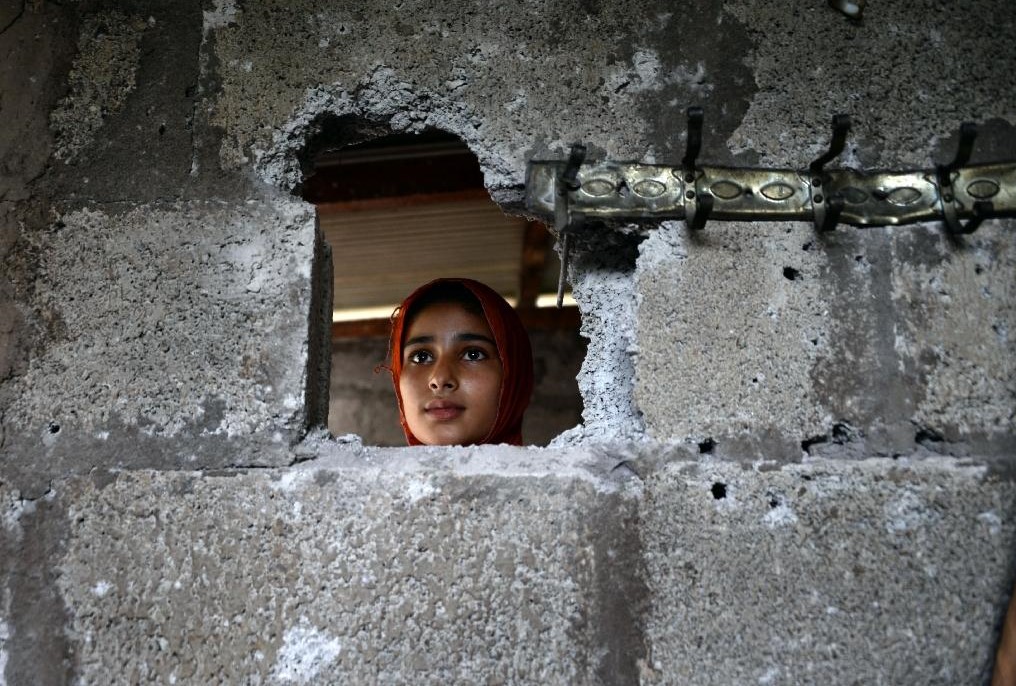 A Pakistani Kashmiri, affected by cross border firing, shows the damaged wall hit by mortar shell at her home in Dhair Bazar, Madarpur sector on the on the Line of Control (LoC ) in Azad Kashmir on August 8, 2015 (AFP/ File Photo)