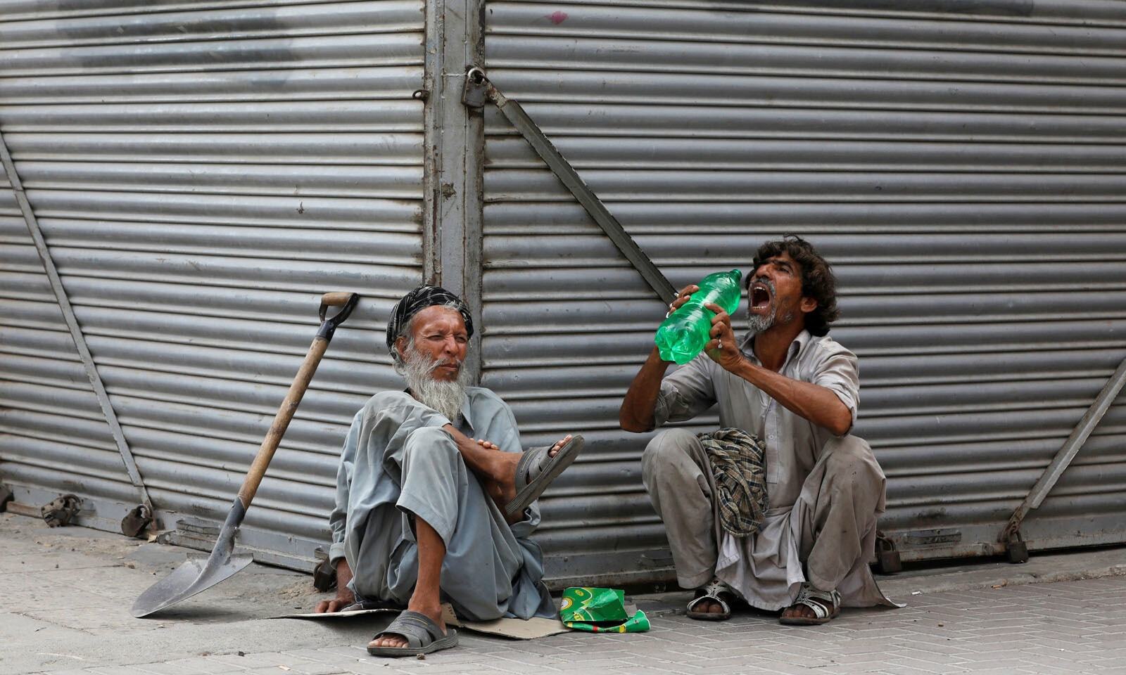 In this file photo, daily wage laborers wait for work as they sit outside closed shops, during lockdown amid the outbreak of coronavirus disease (COVID-19), at a market in Karachi on April 14, 2020. (REUTERS)