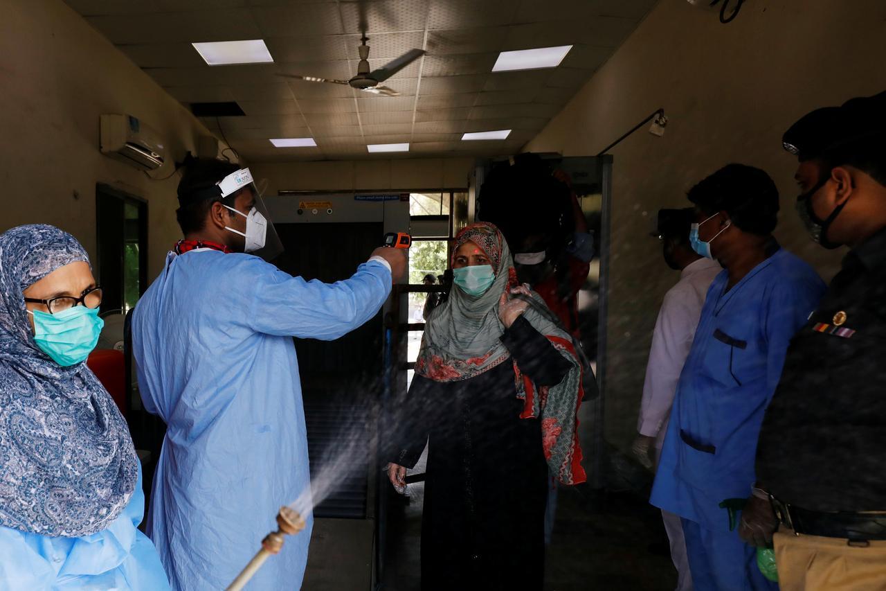 ailway workers wearing protective gears measure the temperature and disinfect passengers before they board a train as they return to their hometowns, after Pakistan started easing the lockdown restrictions and allowed to resume passenger trains, following the coronavirus disease (COVID-19) outbreak, in Karachi, Pakistan May 20, 2020. (REUTERS/ File Photo)