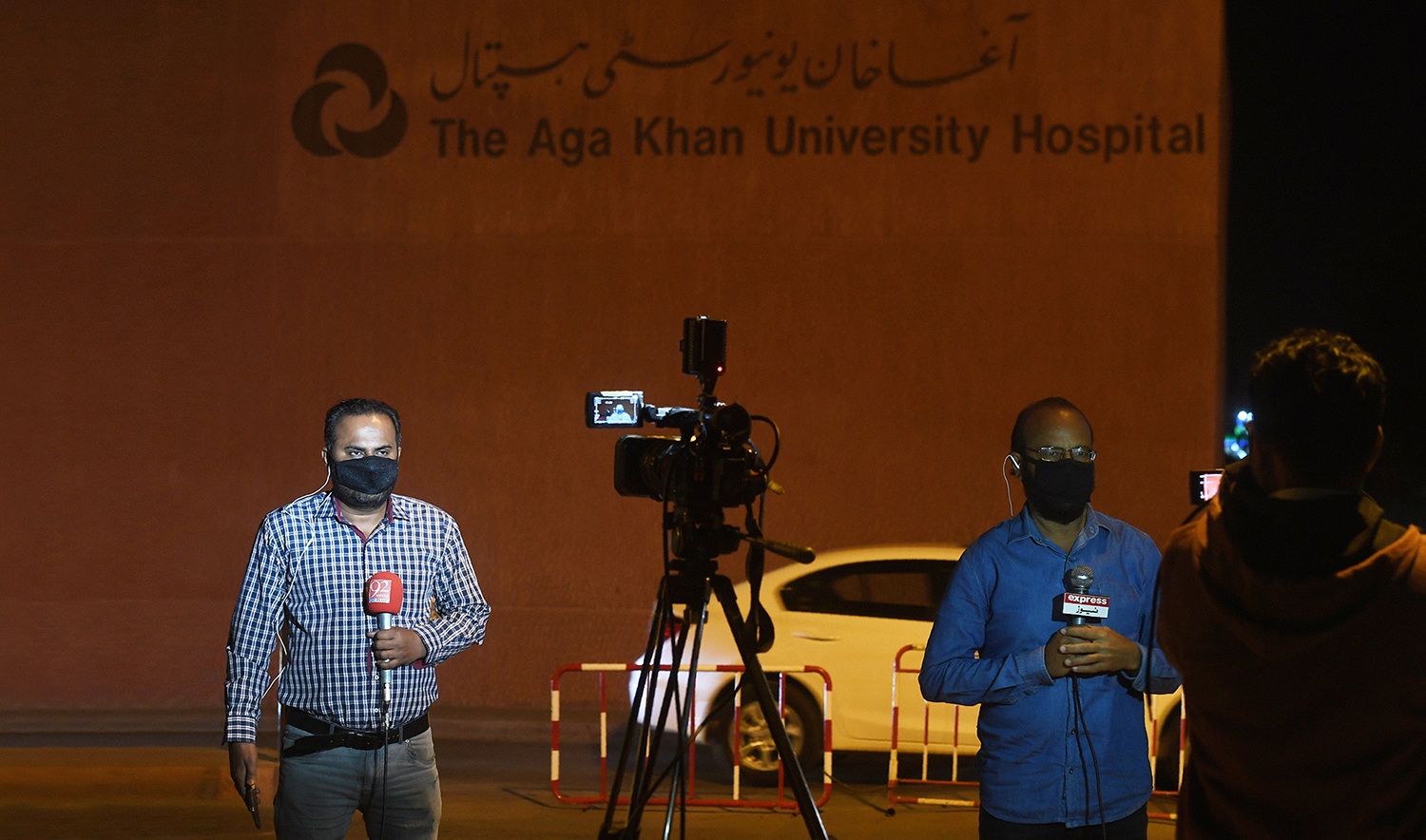 In this file photo, Pakistani journalists wearing protective facemasks report outside the Aga Khan University Hospital where a patient of the COVID-19 novel coronavirus has been admitted in Karachi on Feb. 26, 2020. (AFP)